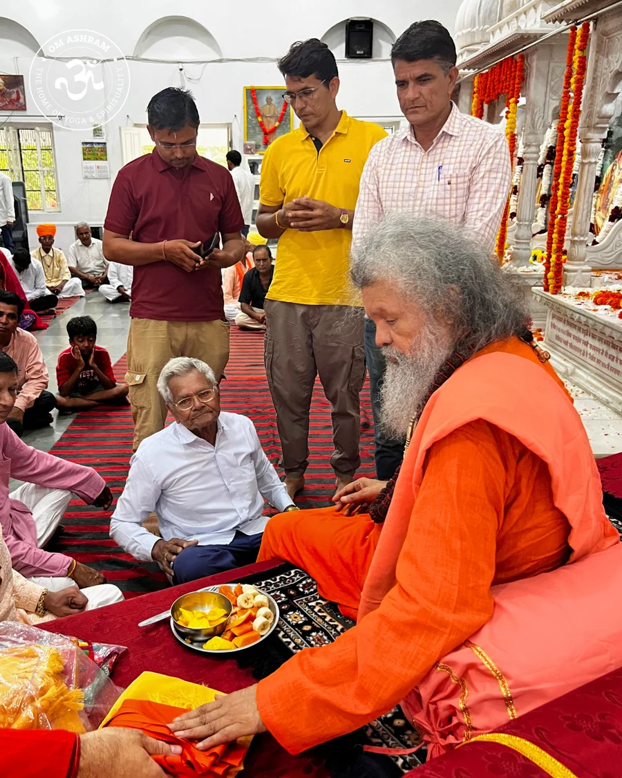 Gurudev Shree Vishwaguru Maheshwarananda Puri Ji Maharaj surrounded by devotees during satsang.